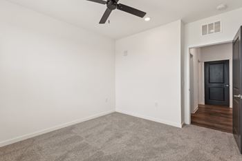 A room with a ceiling fan and carpeted floor.